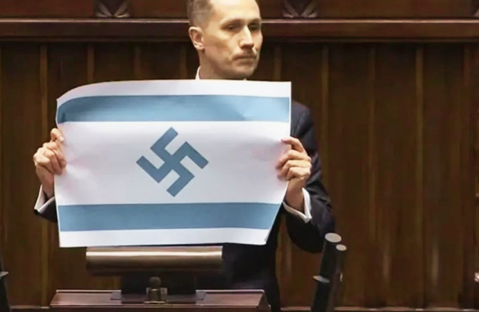 গাজায় শিশু মৃত্যুর প্রতিবাদ জানাতে গিয়ে পোলিশ পার্লামেন্টে ইসরায়েলের পতাকায় নাৎসিদের ‘স্বস্তিকা’ প্রতীক প্রদর্শন করে তীব্র বিতর্ক ও আইনি ব্যবস্থার মুখে পড়েছেন সংসদ সদস্য কনরাড বার্কোভিচ।